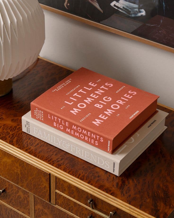 Coffee table photo albums stacked on a wooden console