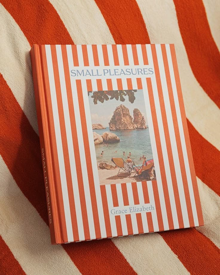 Striped hardcover travel photobook on a beach towel